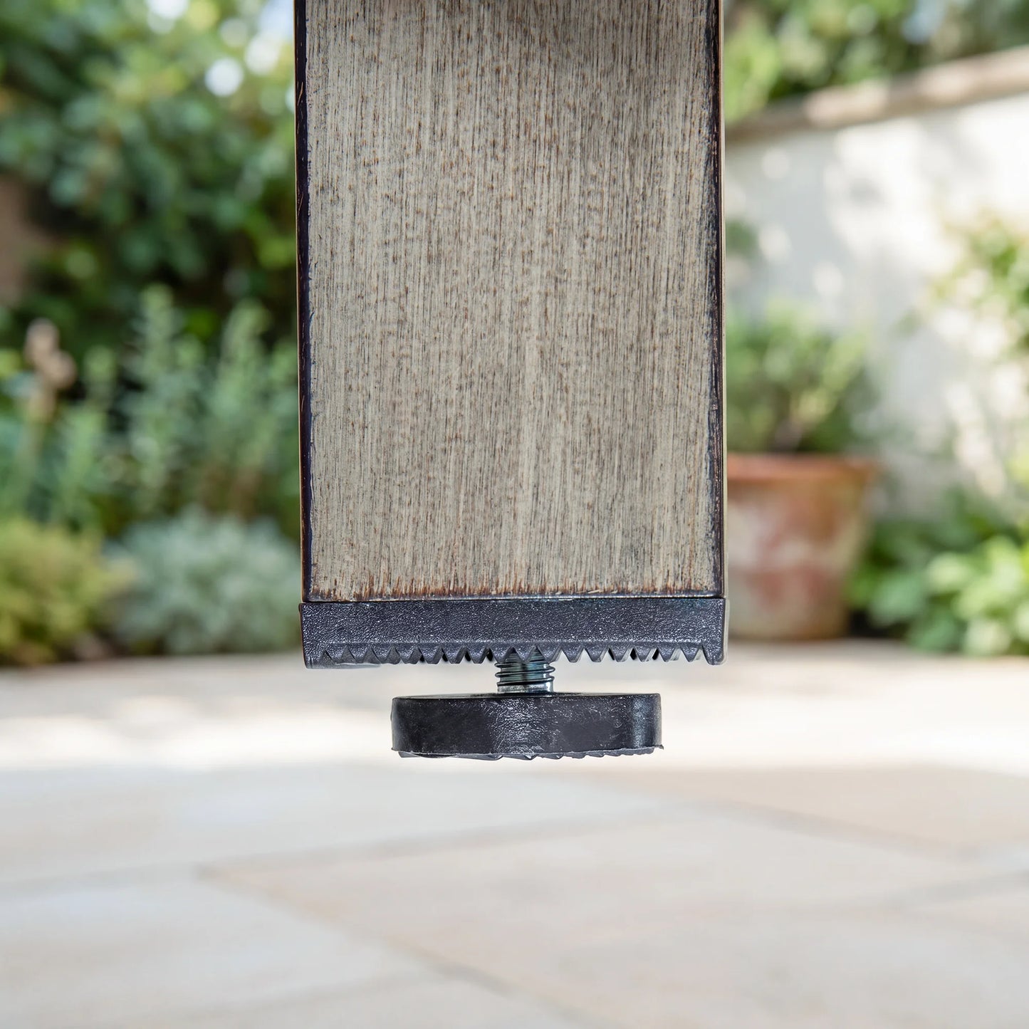 Textured rectangular object with black base on a blurred outdoor background