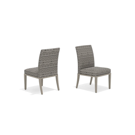 Two gray wicker chairs with cushions