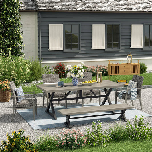 Outdoor patio set with table and chairs on a gravel patio in front of a house.