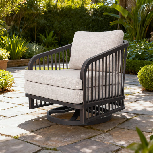 Outdoor chair with beige cushions on a stone patio surrounded by greenery