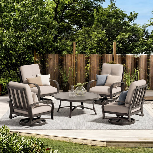 Outdoor patio set with four chairs and a table on a deck with greenery and a wooden fence in the background.