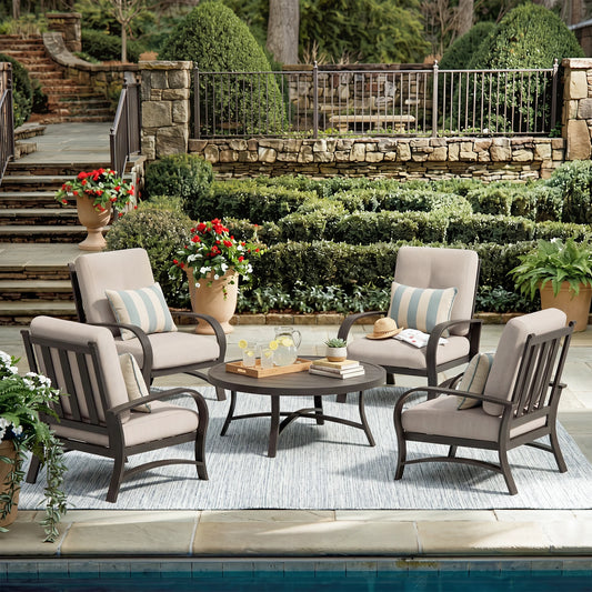 Outdoor patio set with chairs and a table in a garden setting.