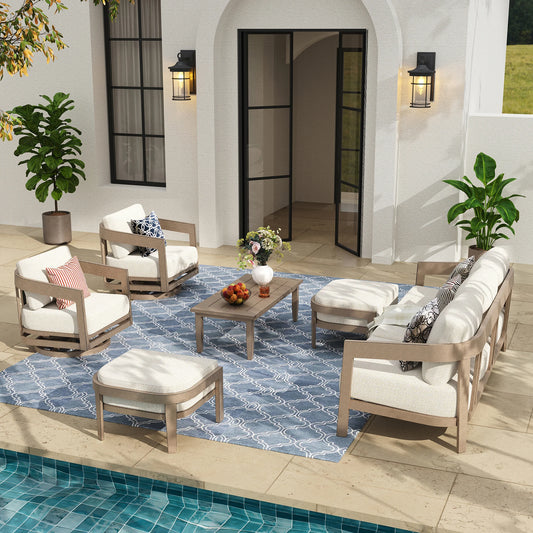 Outdoor patio furniture set with cushions by a poolside area.