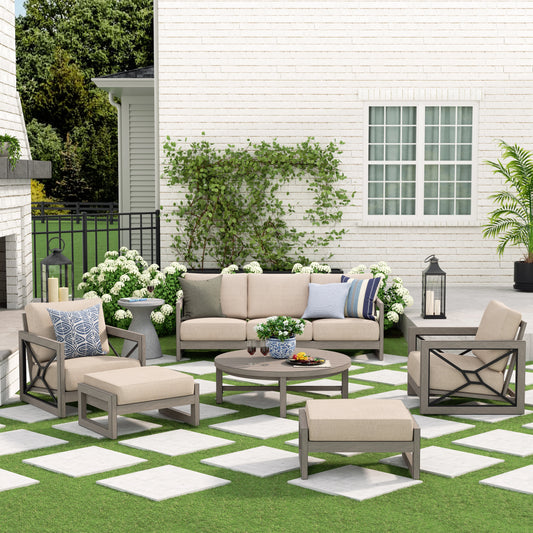 Outdoor patio set with beige furniture and cushions on a green lawn.