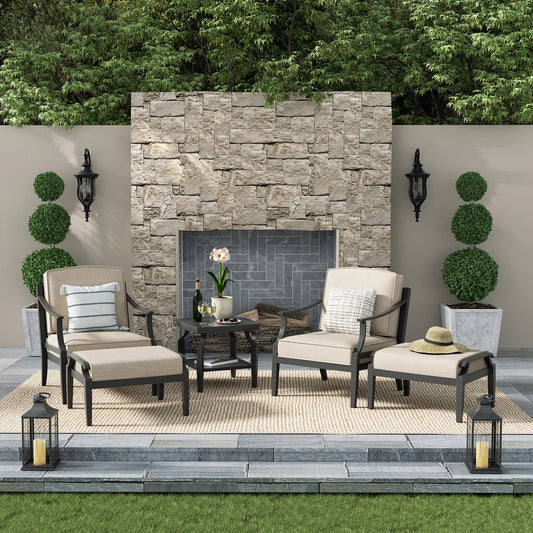 Outdoor patio set with chairs, side table, and ottoman in a garden setting.