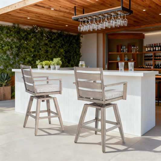 Outdoor bar area with two wooden stools and a white counter, surrounded by greenery.