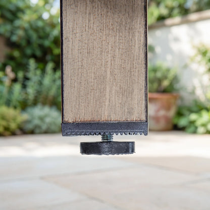 Wood-look panel with black base on a blurred outdoor background