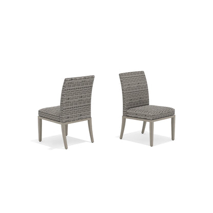 Two gray wicker chairs with cushions 