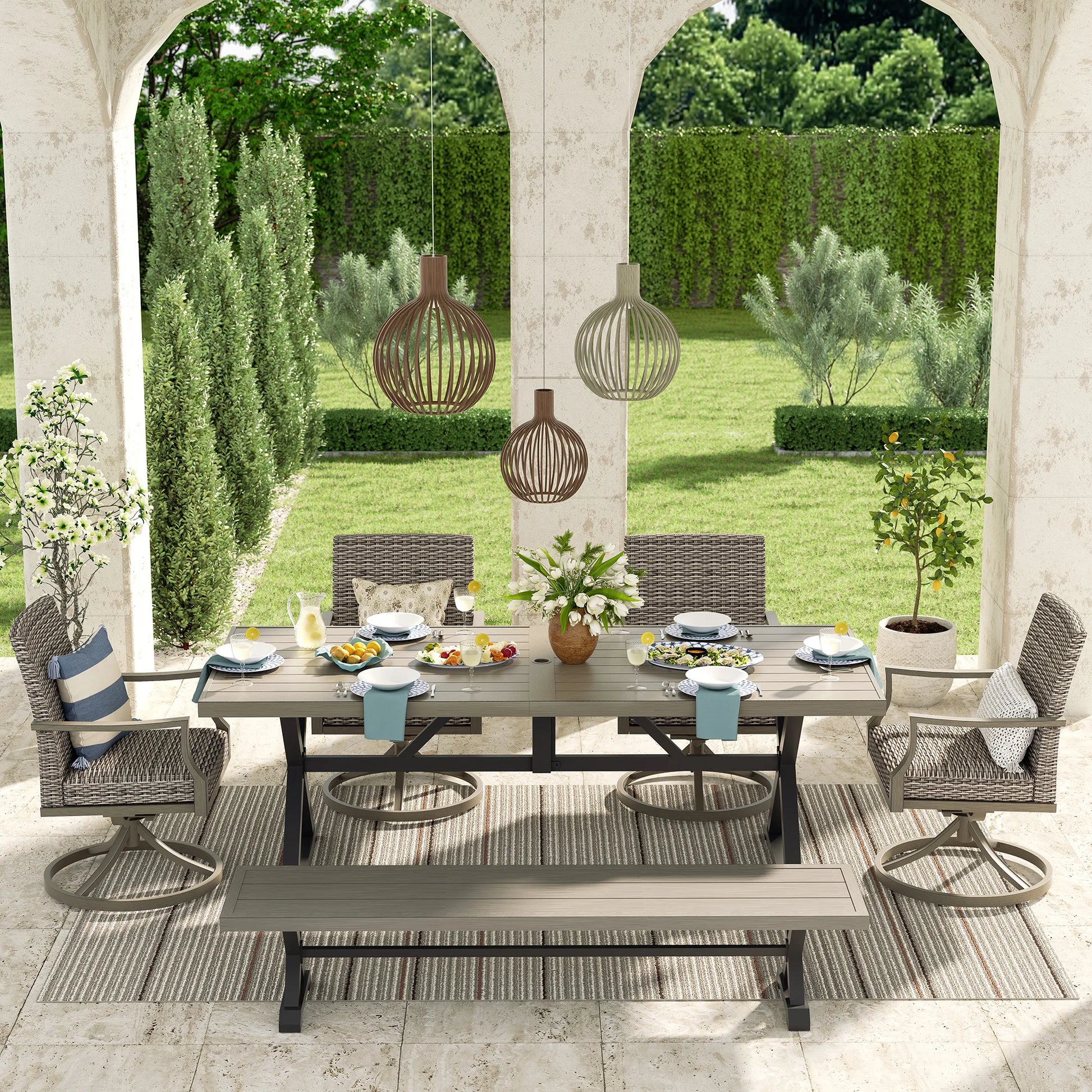 Outdoor patio set with table, chairs, and decorations in a garden setting.