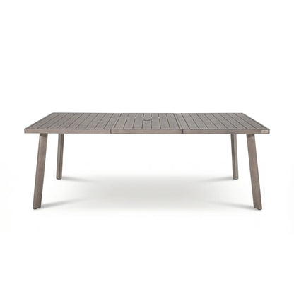 A rectangular outdoor dining table with a weathered gray-brown slatted top and matching tapered legs, shown on a clean white background.