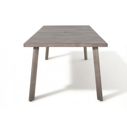 A rectangular outdoor dining table with a weathered gray-brown slatted top and four tapered legs, shown on a clean white background.