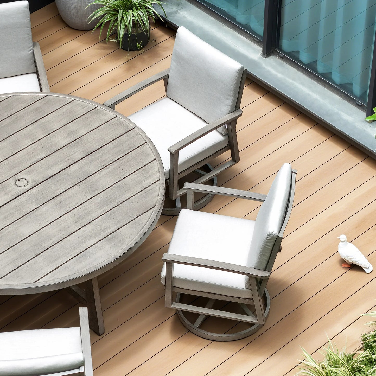 Outdoor furniture set with round table and chairs on a wooden deck.