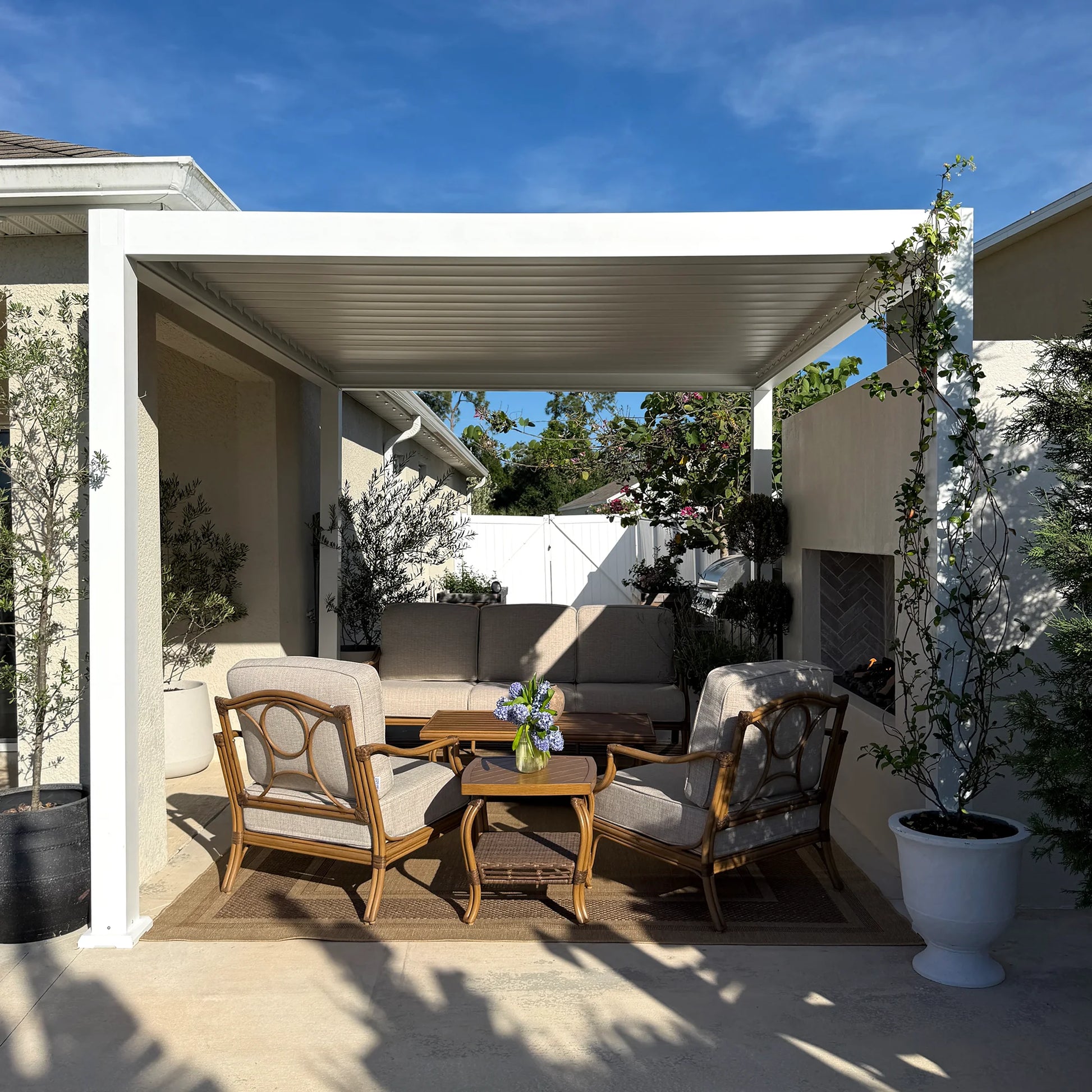 Outdoor patio area with wooden furniture and a white pergola.