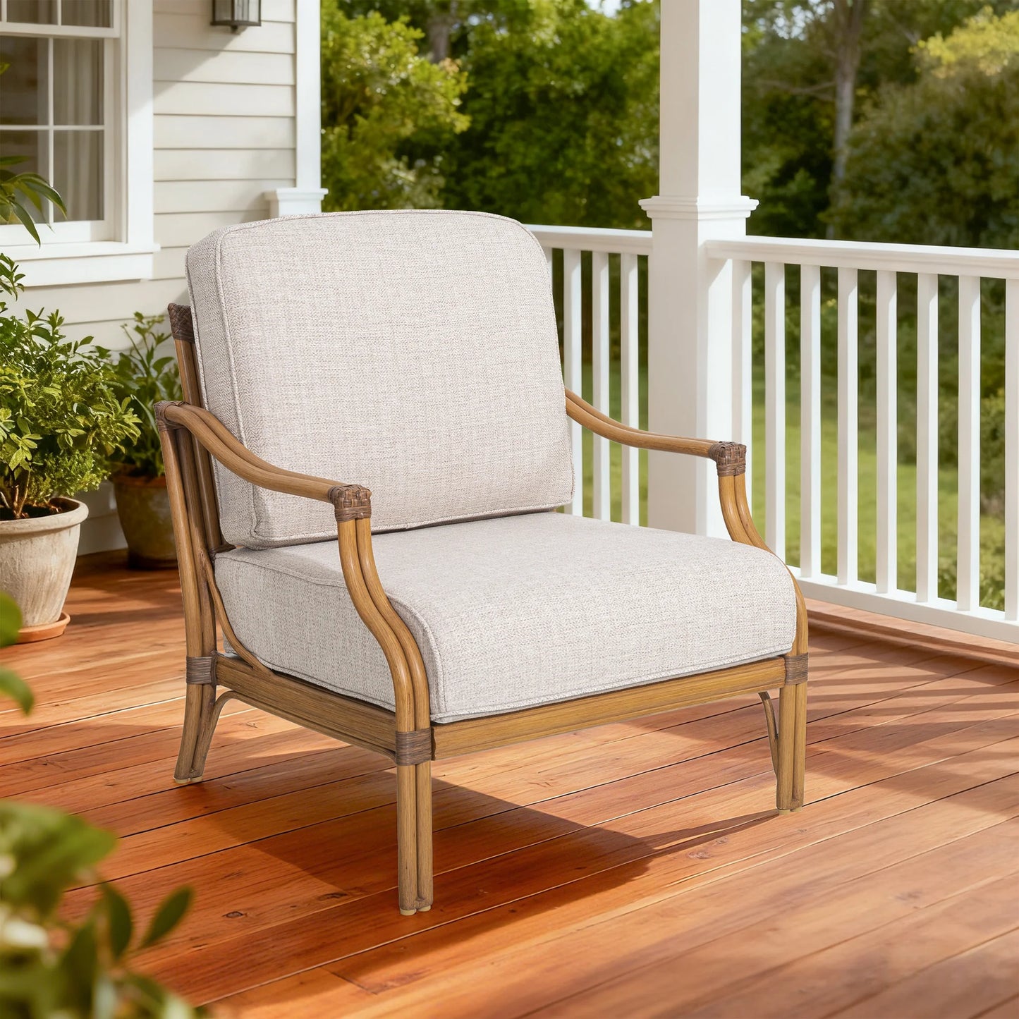 Chair with beige cushion on a wooden deck with greenery in the background