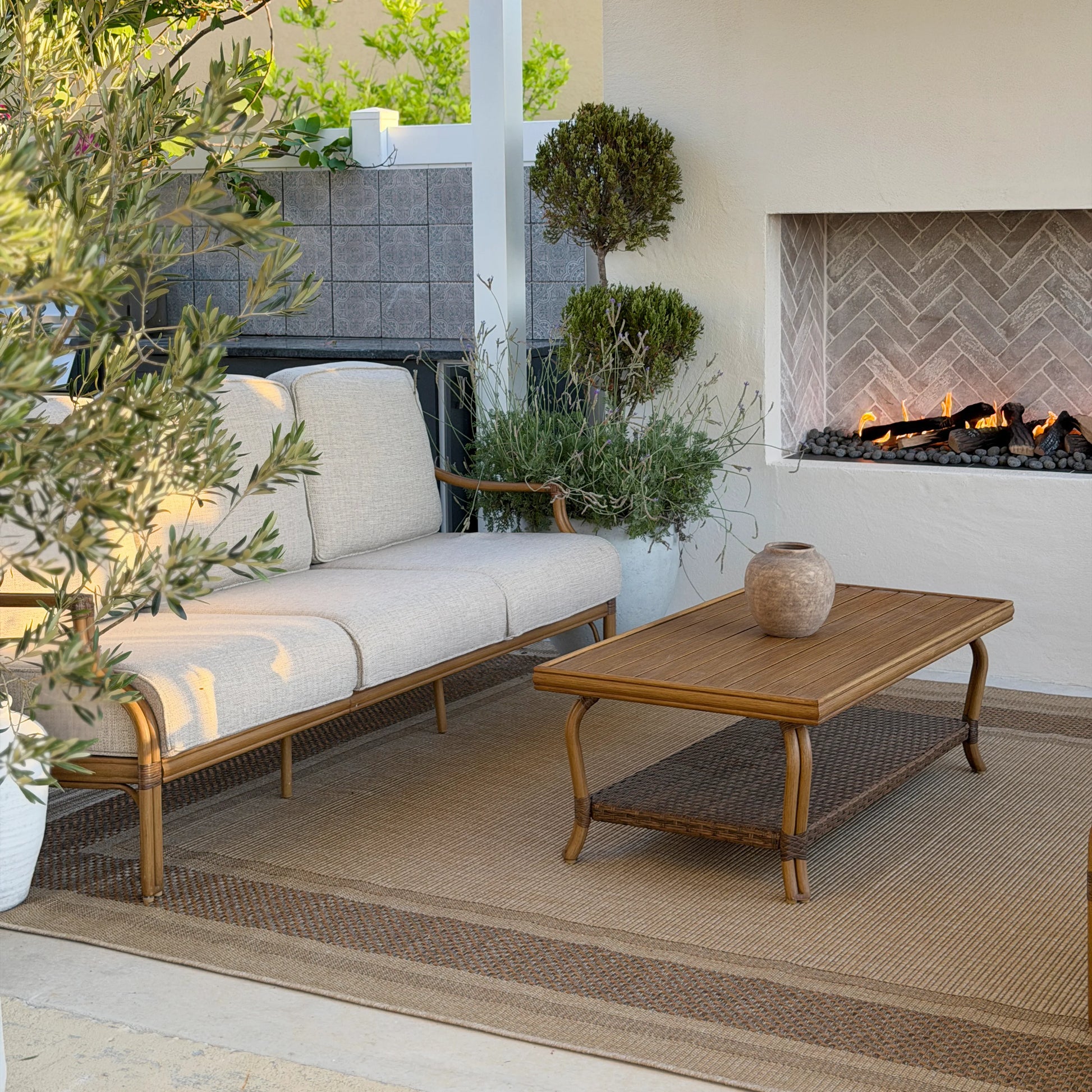 Outdoor patio with a sofa, coffee table, and fireplace.