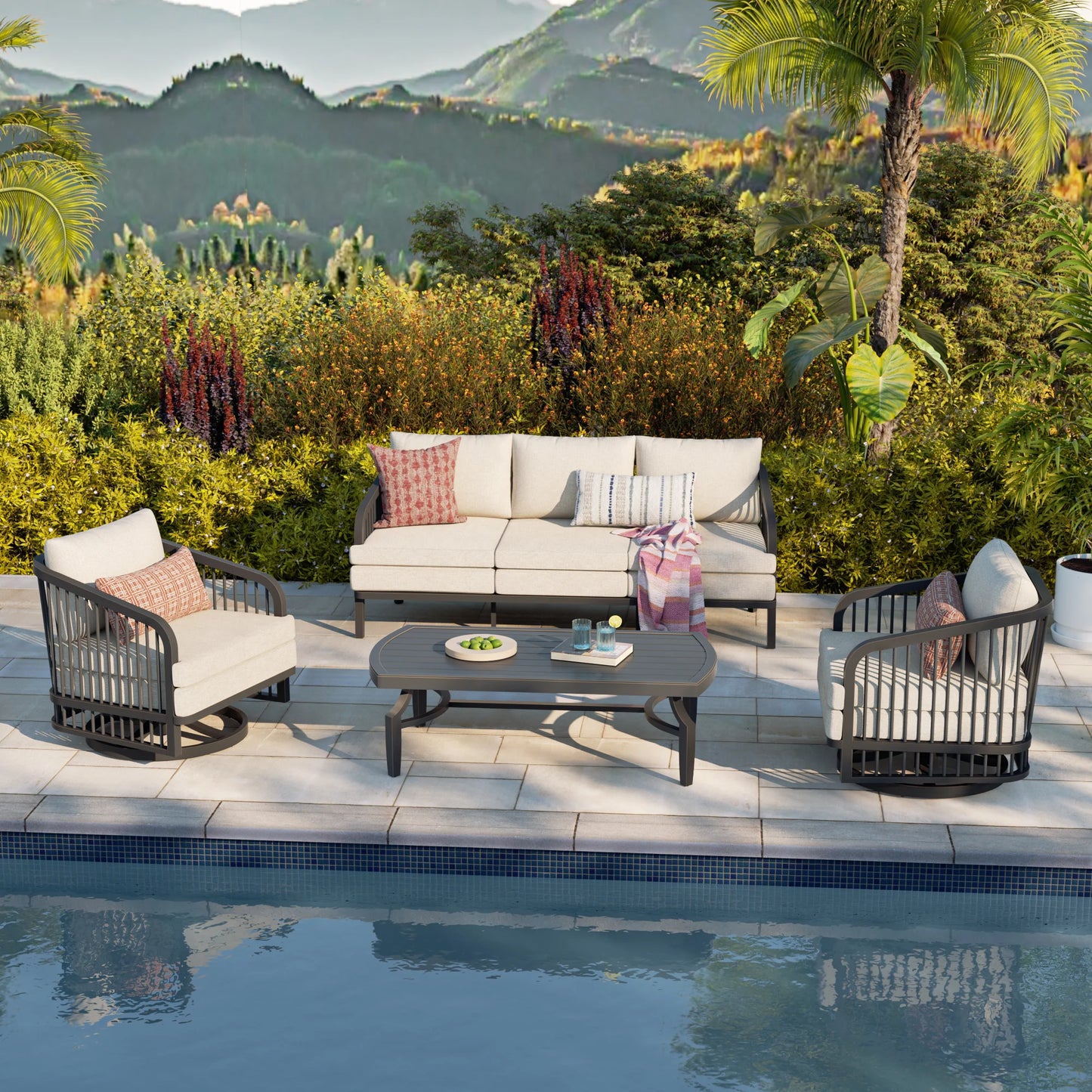 Outdoor patio set with furniture by a poolside, surrounded by greenery and mountains.