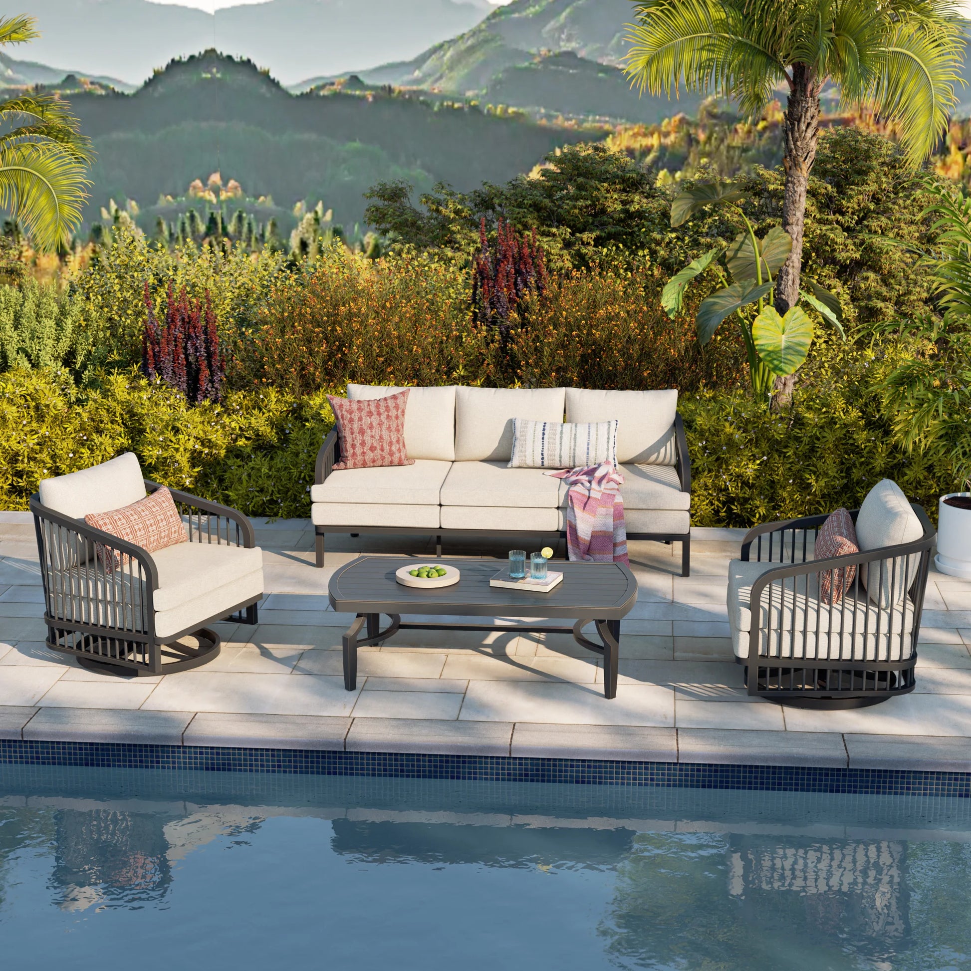 Outdoor patio set with furniture by a poolside, surrounded by greenery and mountains.