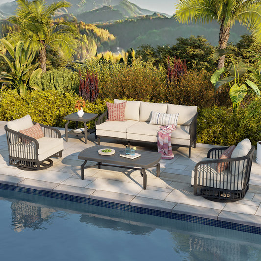 Outdoor patio set with furniture by a poolside, surrounded by greenery and mountains.