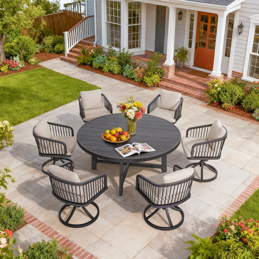 Outdoor patio set with a round table and chairs on a stone patio in front of a house.