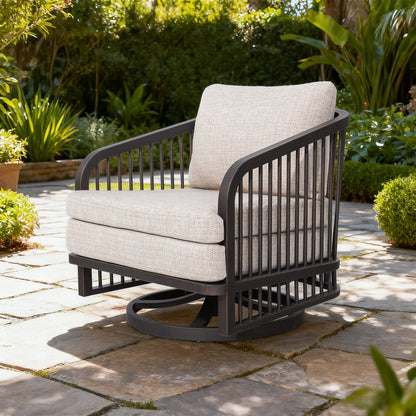 Outdoor chair with beige cushions on a stone patio surrounded by greenery