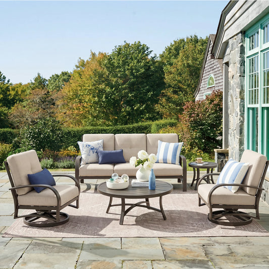 Outdoor patio set with furniture and decor on a stone patio.