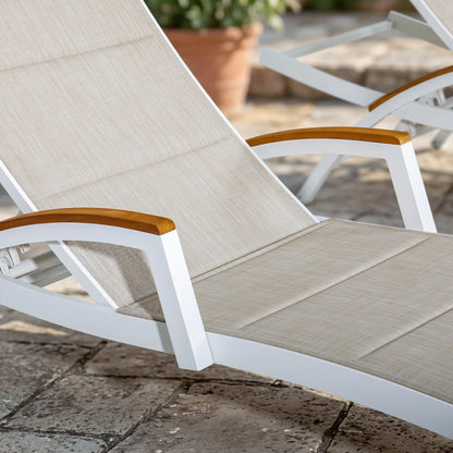 Beige lounge chair with wooden armrests on a stone patio