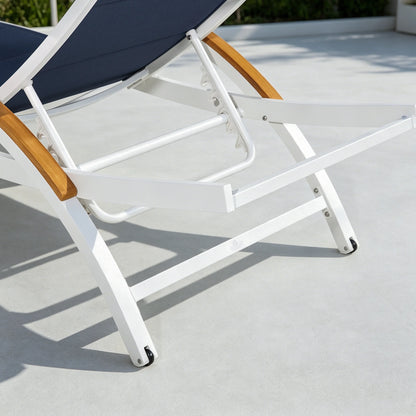 Close-up of a lounge chair with white frame, wooden armrests, and navy cushion on a light gray surface.