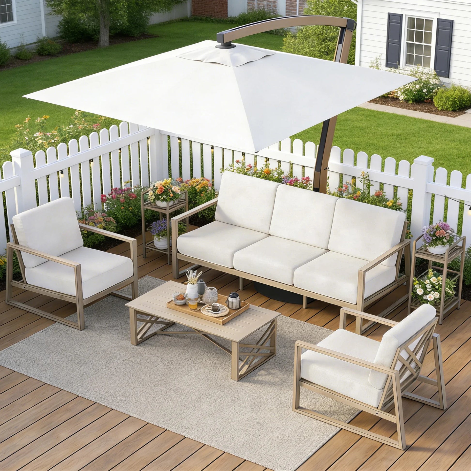 Outdoor patio set with white cushions on a wooden deck, featuring a sofa, chairs, and a coffee table under an umbrella.