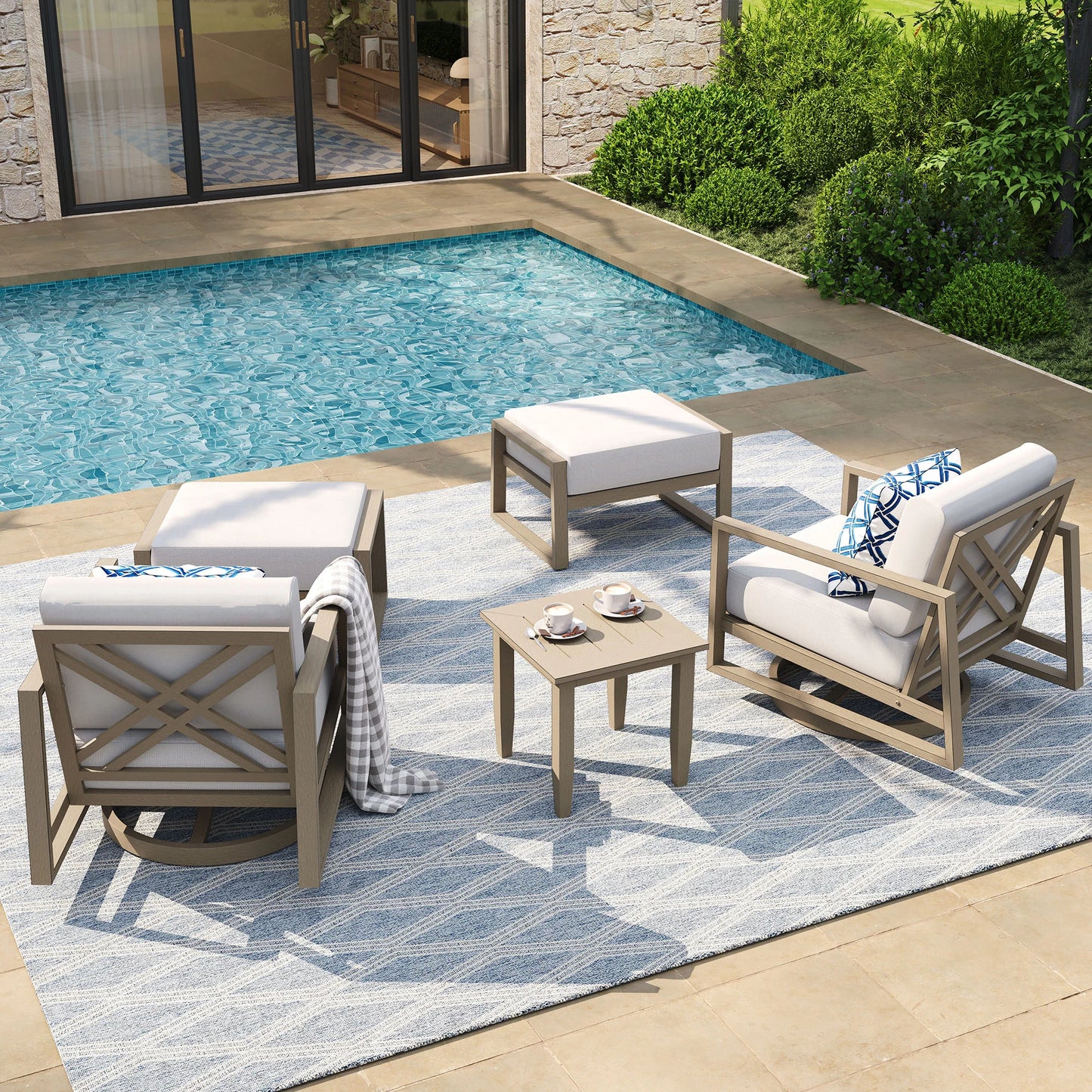 Outdoor patio furniture set by a pool with a stone wall and greenery in the background.