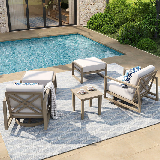 Outdoor patio furniture set by a pool with a stone wall and greenery in the background.
