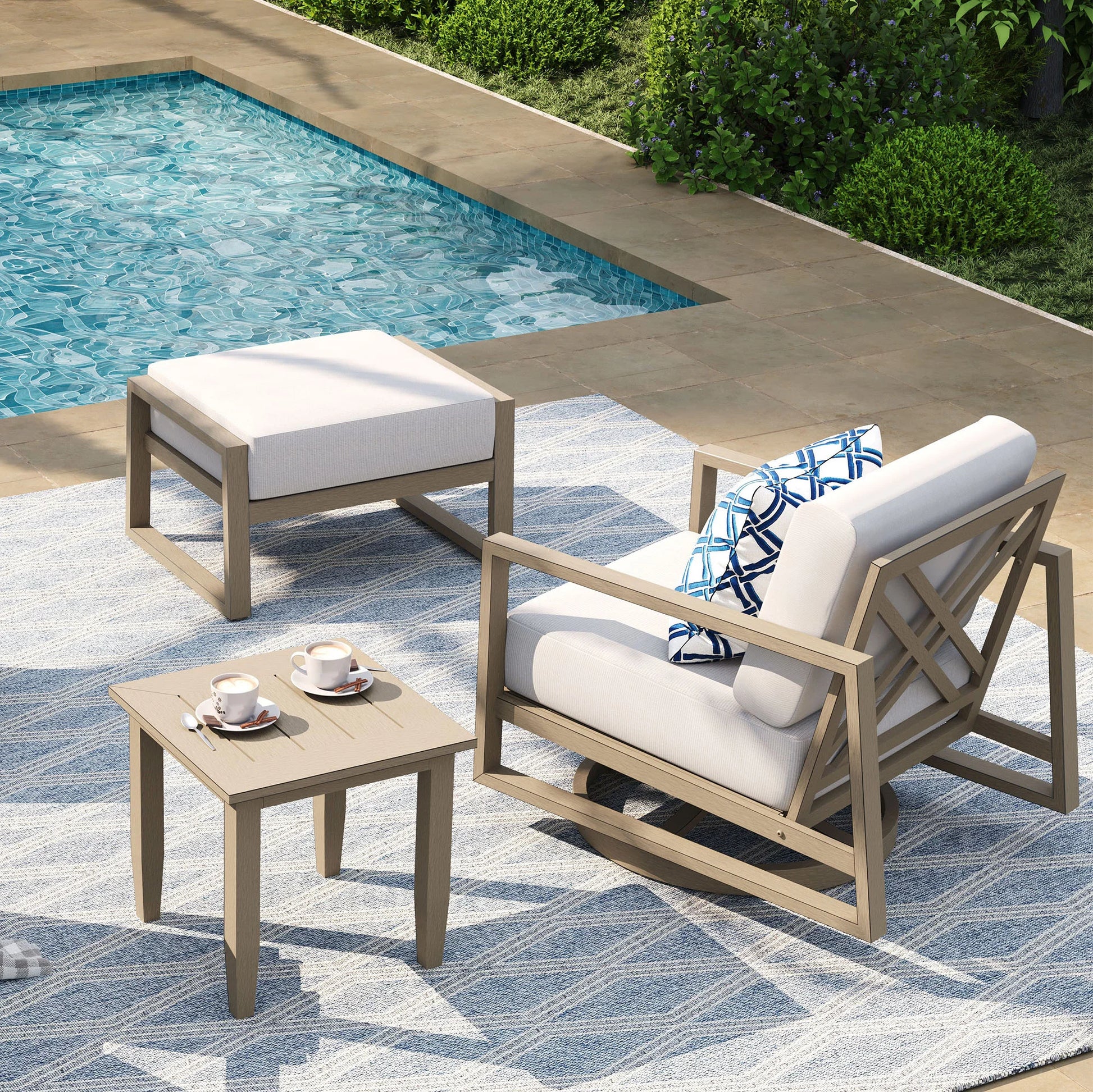 Outdoor patio set with chairs, table, and ottoman by a pool.
