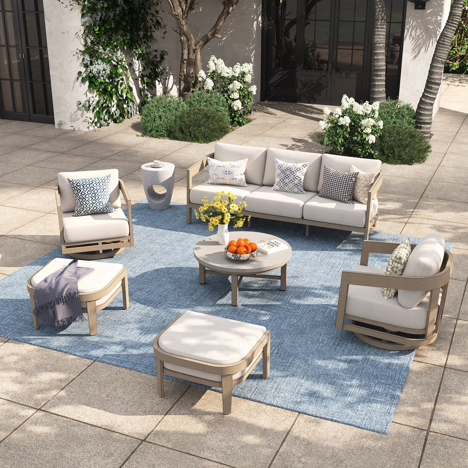 Outdoor patio set with furniture and decor on a blue rug.
