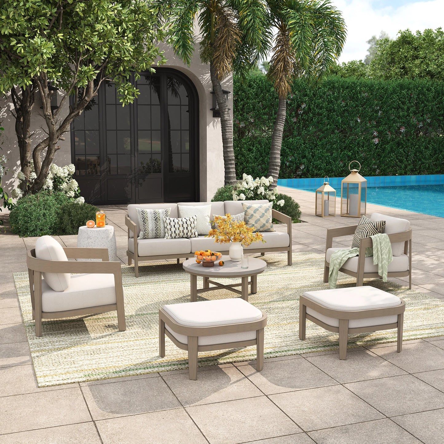 Outdoor patio set with furniture and decor by a poolside.