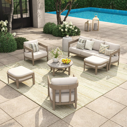 Outdoor patio furniture set with beige and white cushions by a pool.