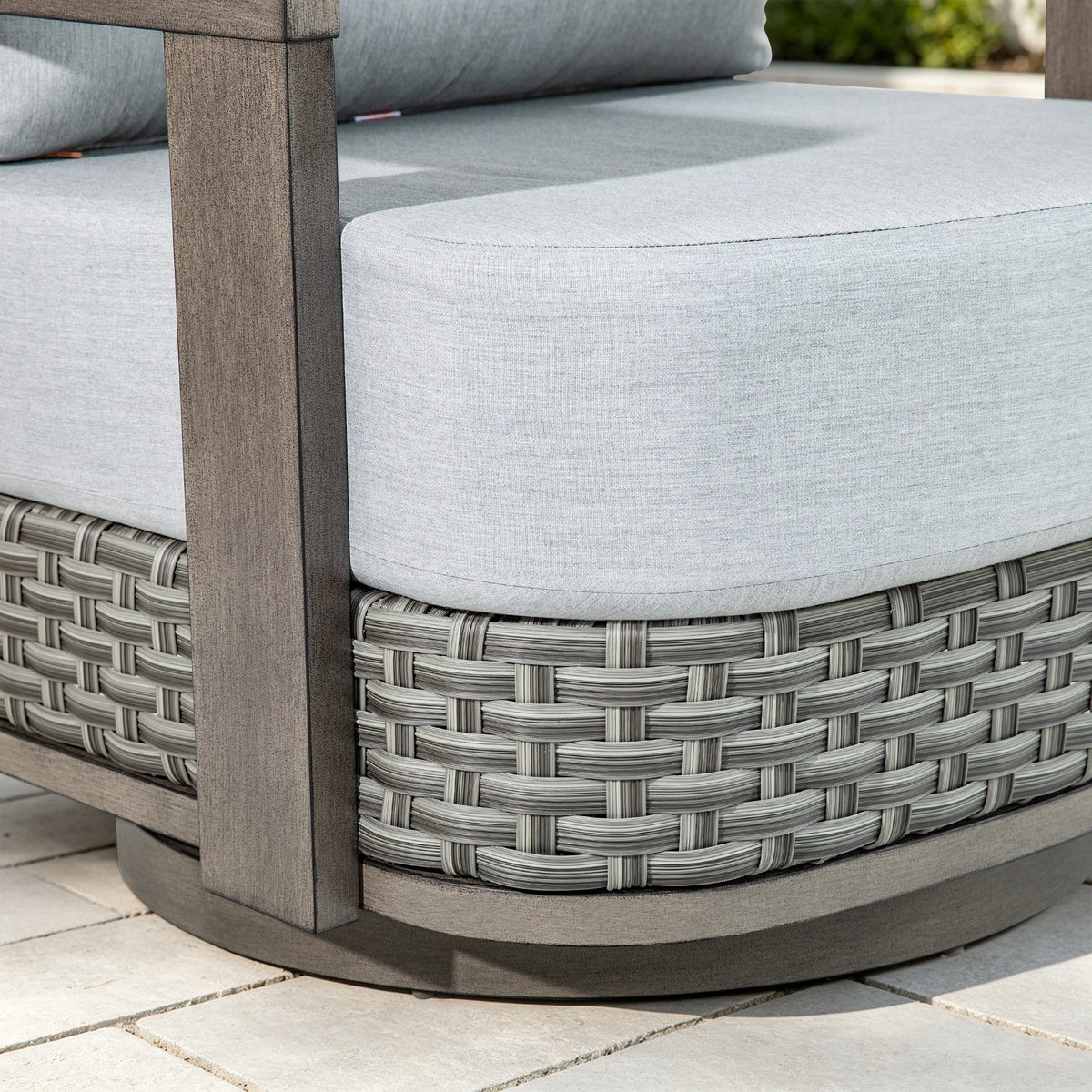 Detailed close-up of the multi-tonal gray PE wicker base and thick patio seat cushion of the club chair.
