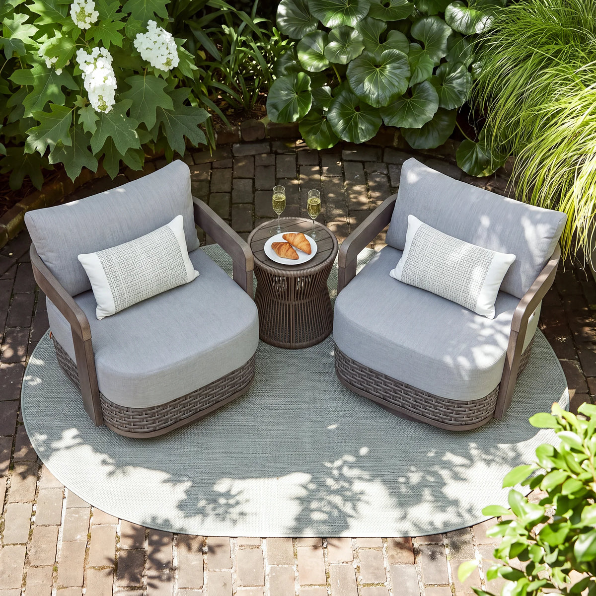 Aerial top-down view of two modern gray patio club chairs and a round wicker side table arranged on an outdoor area rug.
