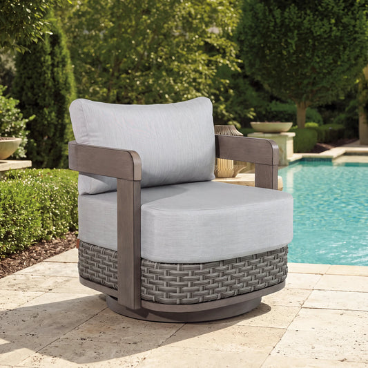 A single Manarola gray wicker swivel club chair placed on a luxury sun terrace next to a swimming pool.