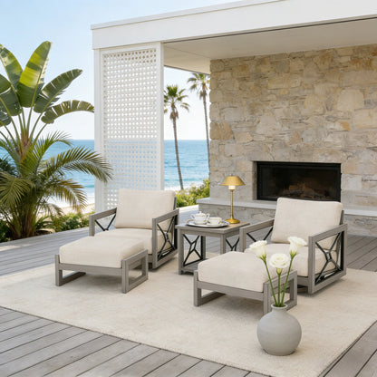 Outdoor patio set with swivel chairs, ottoman, and table on a deck with ocean view.