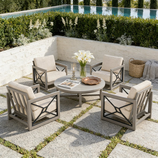 Outdoor patio set with four chairs and a round table by a poolside.