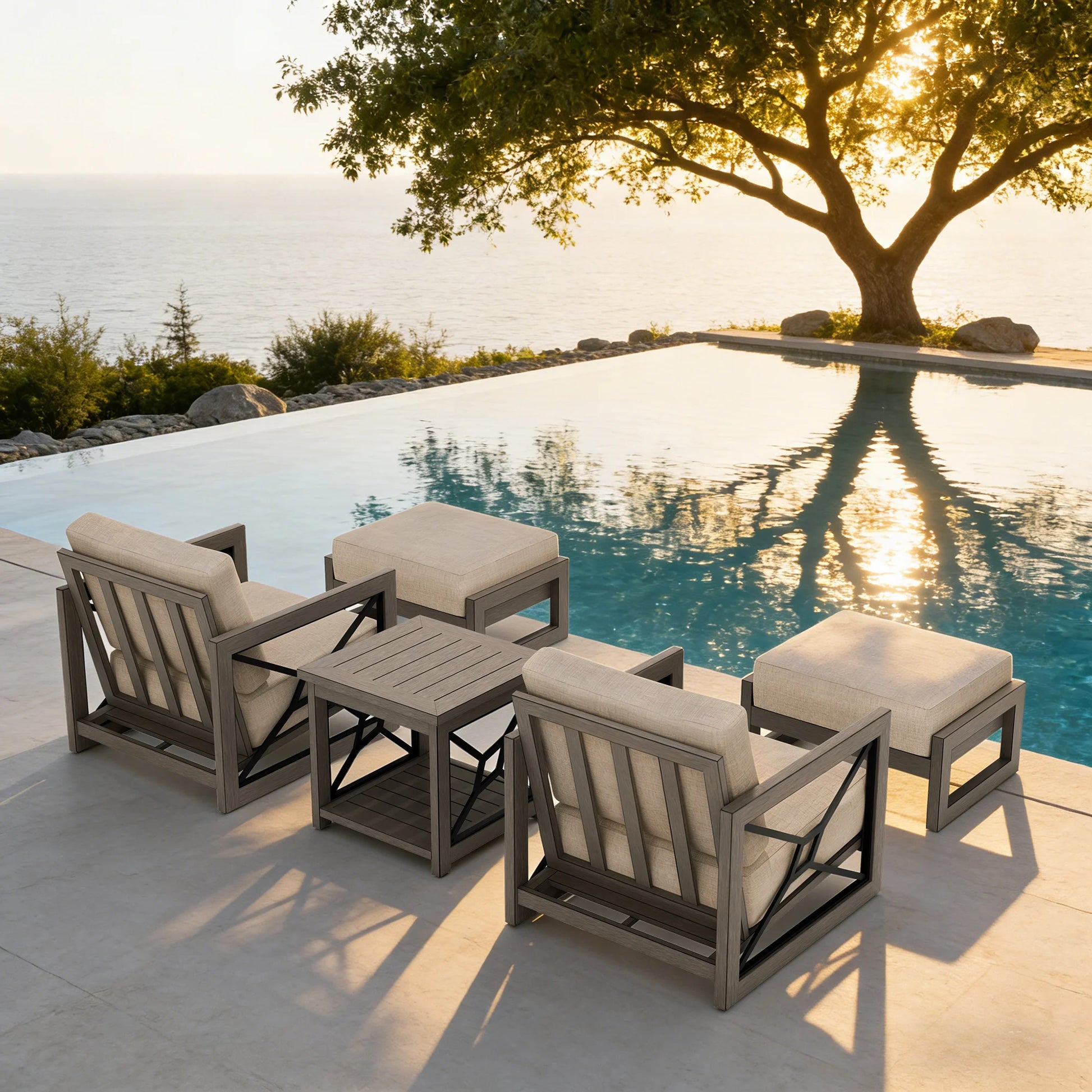 Outdoor furniture set by a pool with a tree and sunset in the background