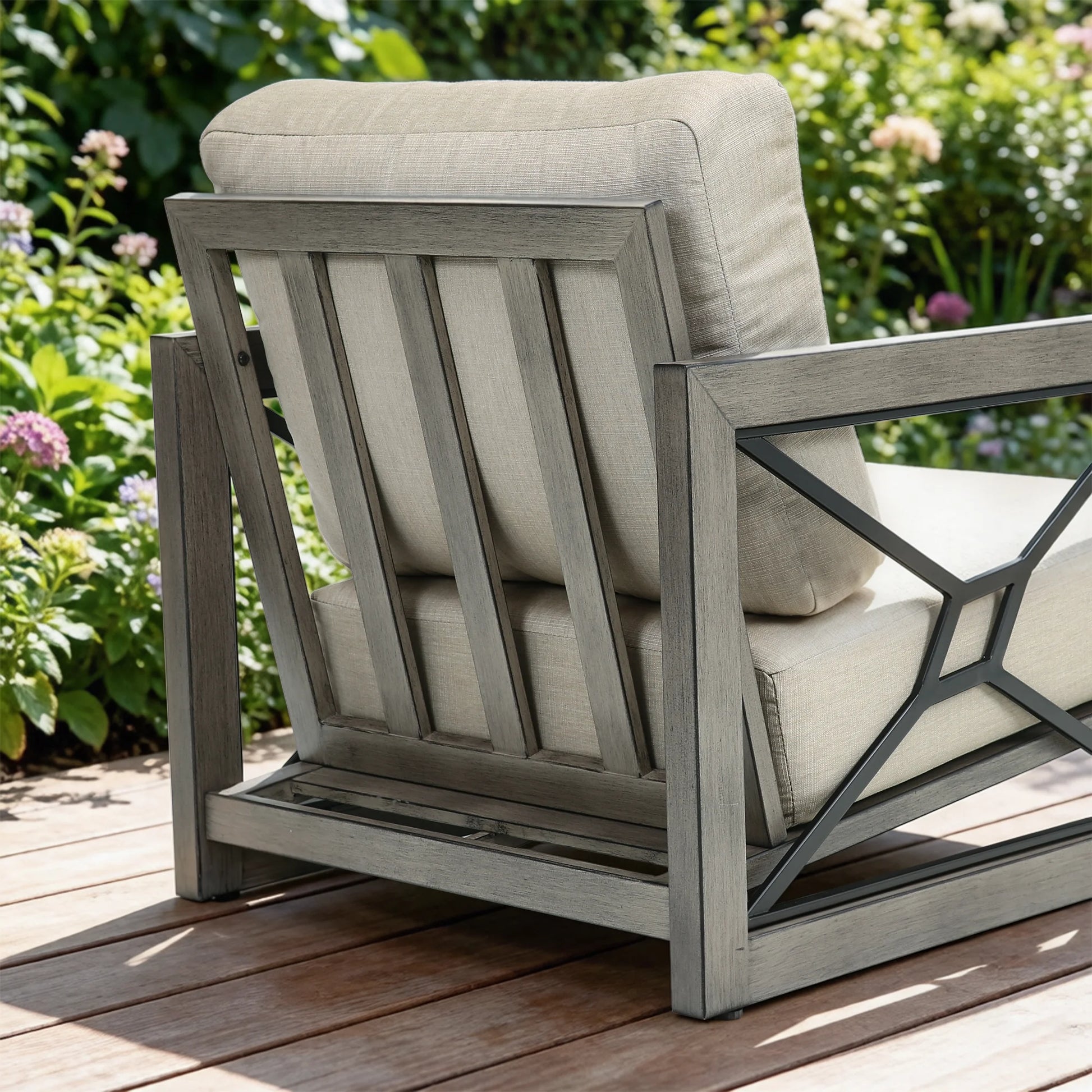Outdoor chair with beige cushions on a wooden deck surrounded by greenery
