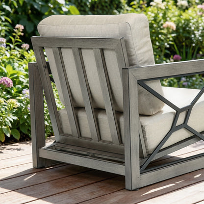 Outdoor chair with beige cushions on a wooden deck surrounded by greenery