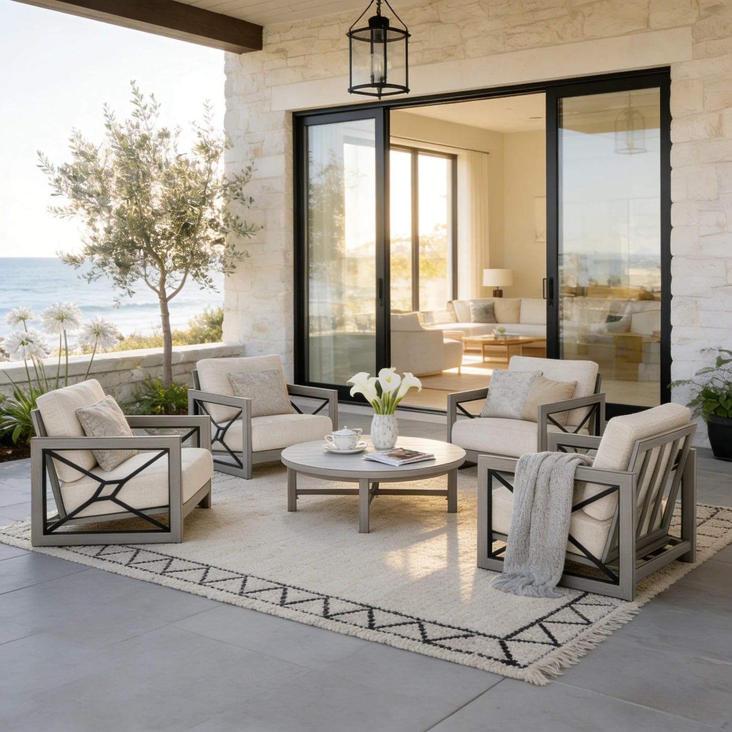Outdoor patio with furniture and decor by a large glass door with a view of the ocean.