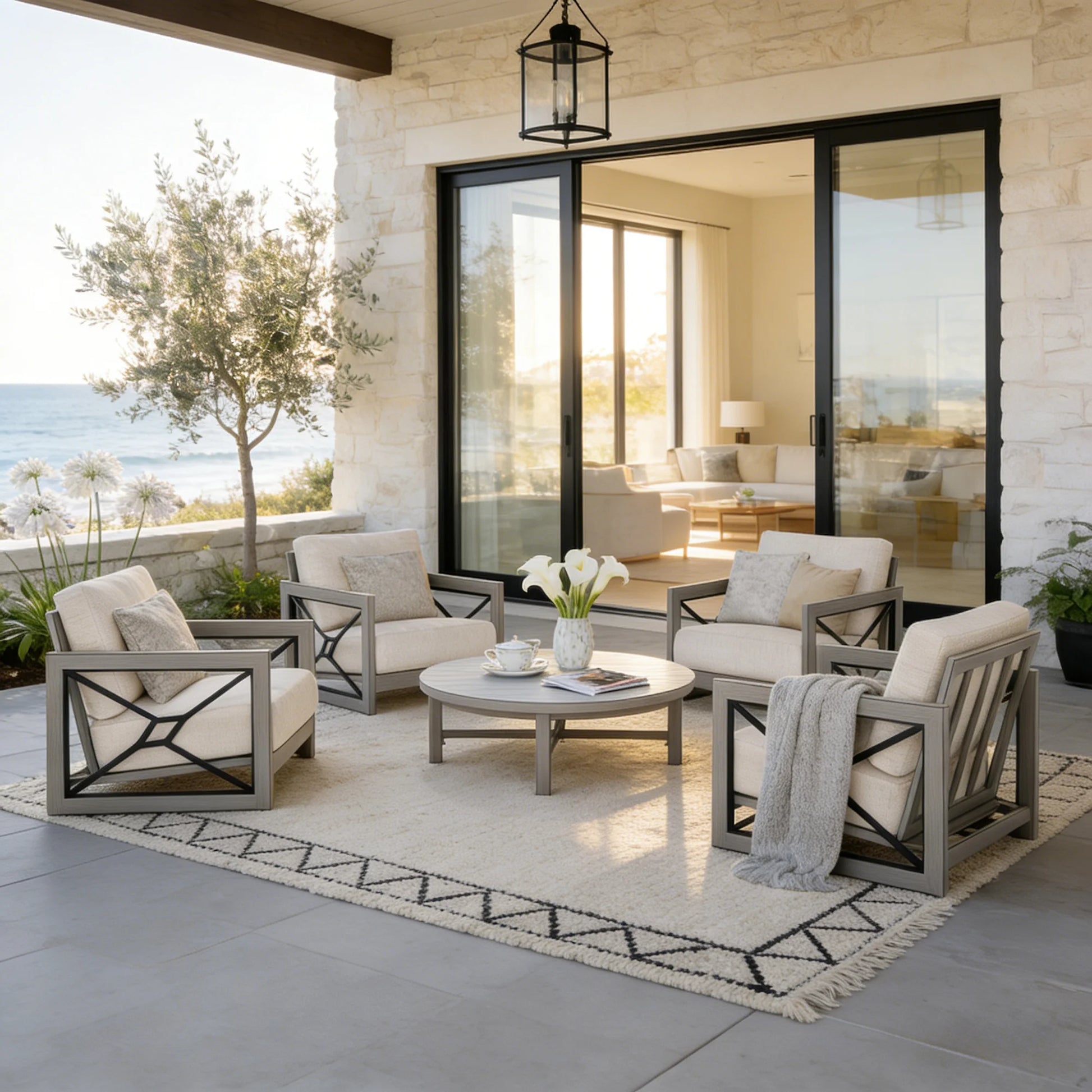 Outdoor patio with furniture and decor by a large glass door with a view of the ocean.