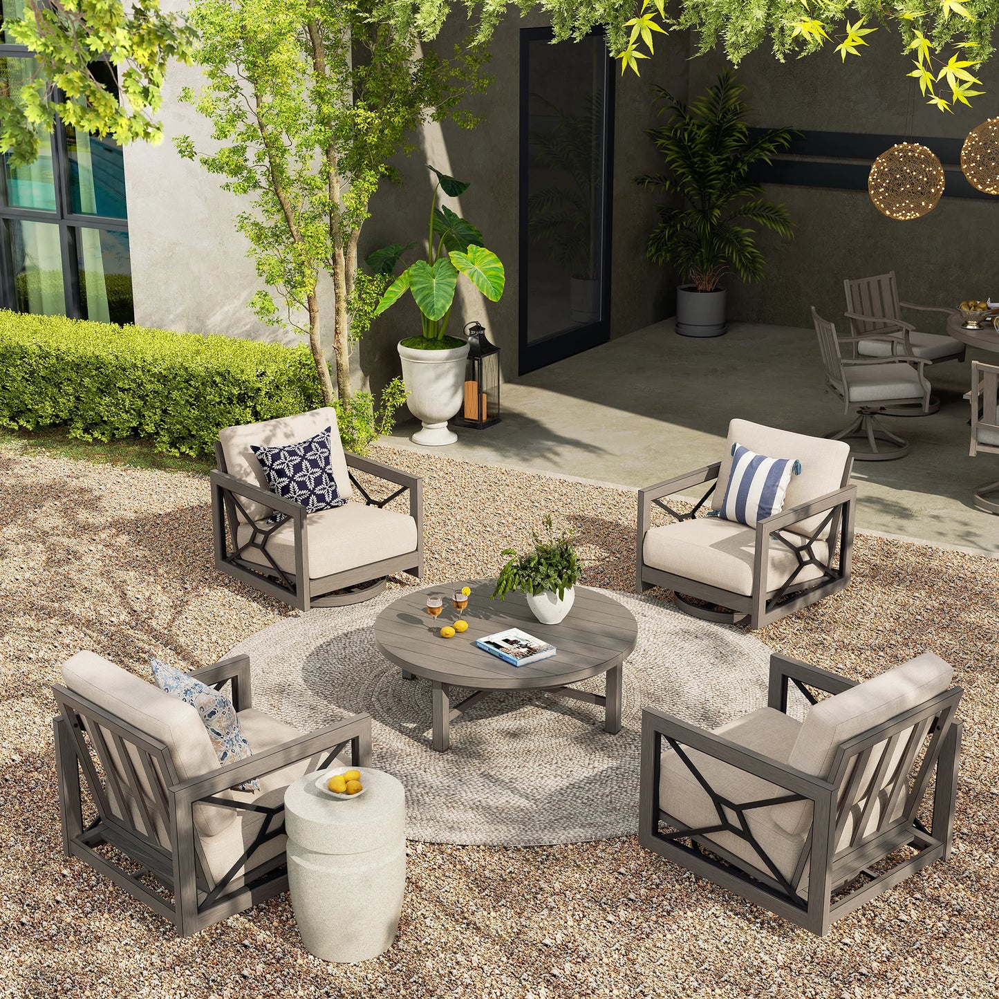 Outdoor patio set with chairs, table, and decor in a garden setting.