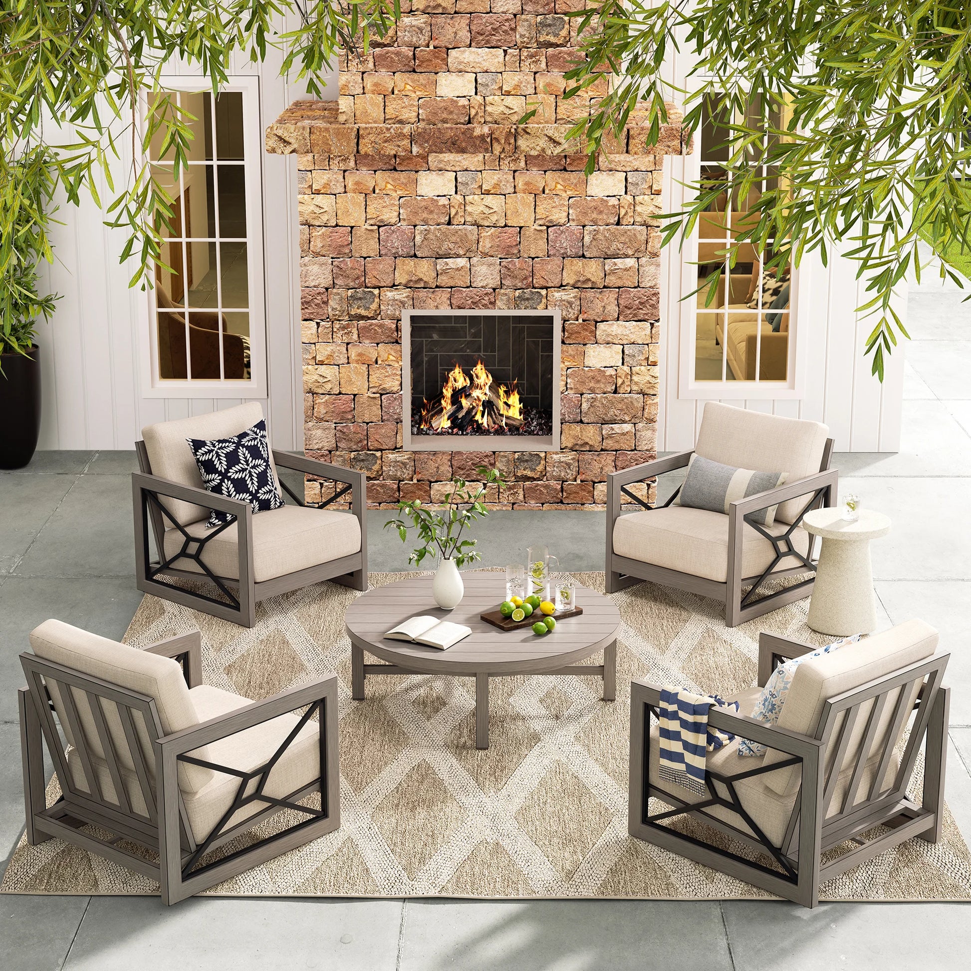 Outdoor patio set with chairs, table, and fireplace against a stone wall.