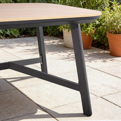 Outdoor table with wooden top and black metal legs on a patio