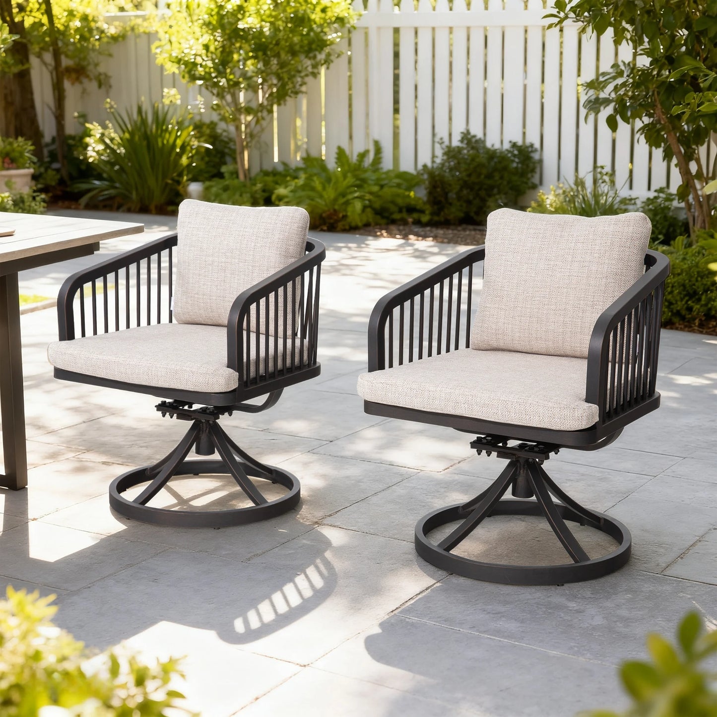 Two outdoor swivel chairs with beige cushions on a patio.