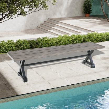 Long wooden bench by a poolside with a garden and steps in the background