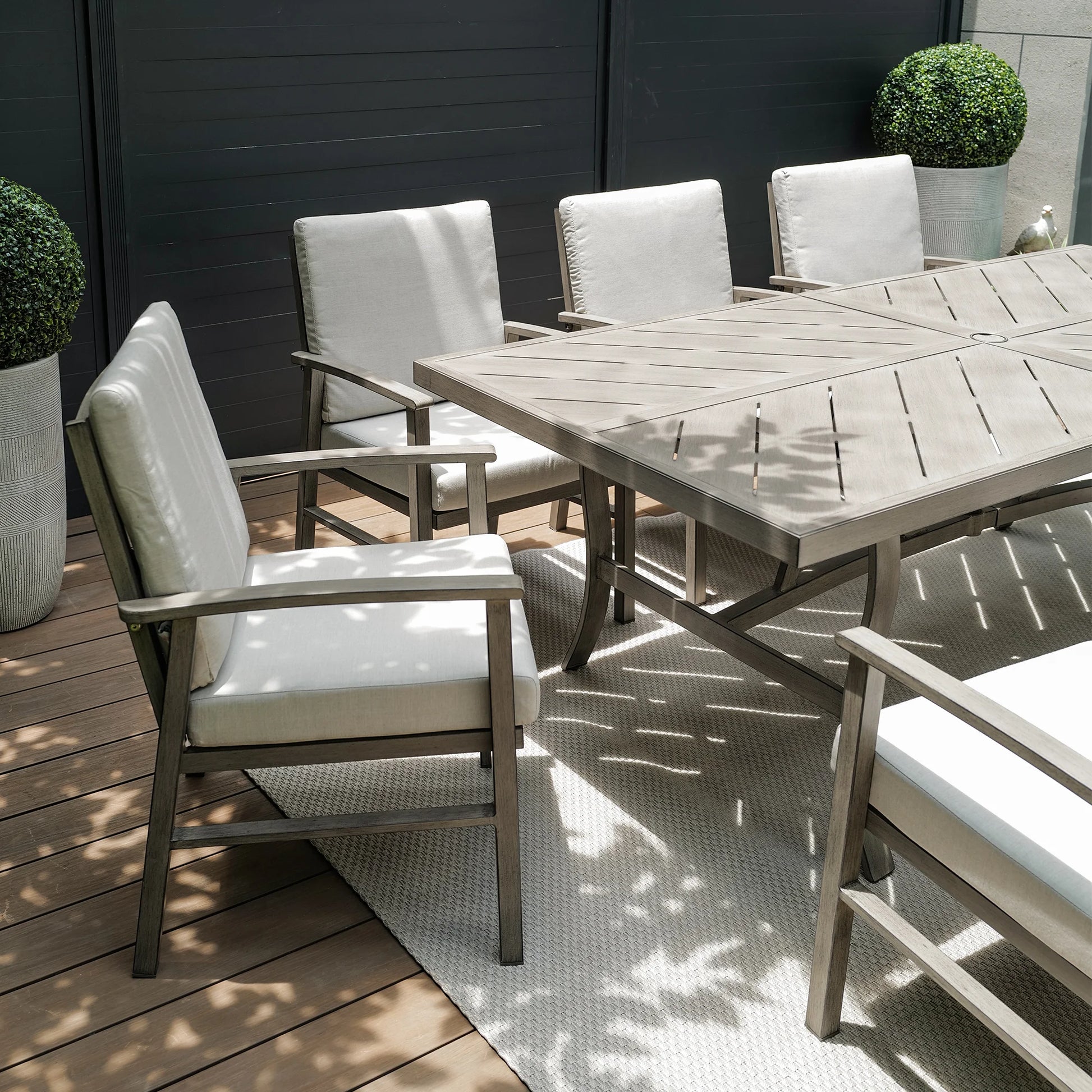 Outdoor dining set with wooden table and chairs on a deck